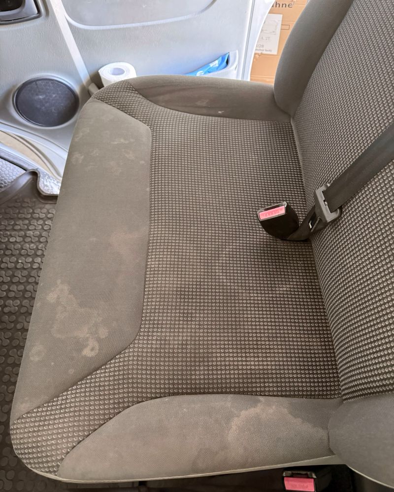 Fleckiger Autositz vor der Innenreinigung in Korb